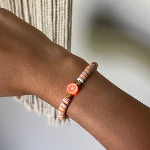 Summer citric bracelet. It is in the color neon orange, gray, and white.